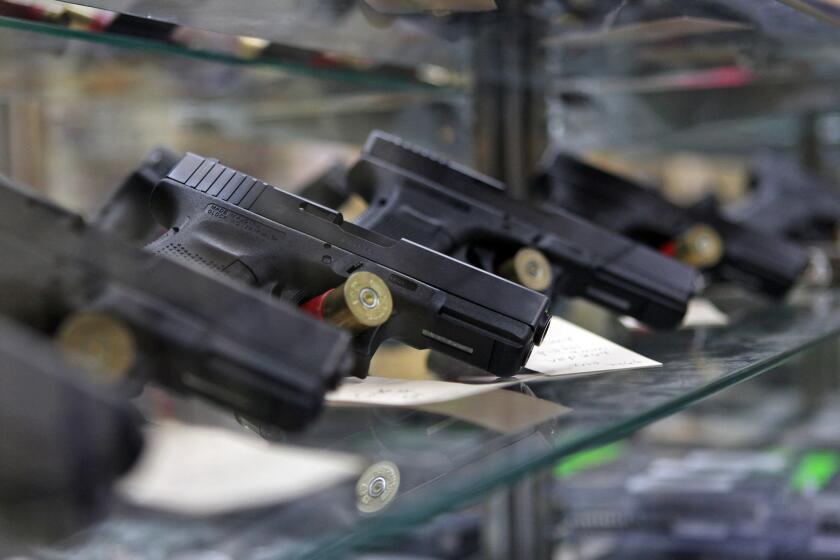 Glock pistols sit on display in a glass case at the Article 2 Gun Store in Lombard, Ill.