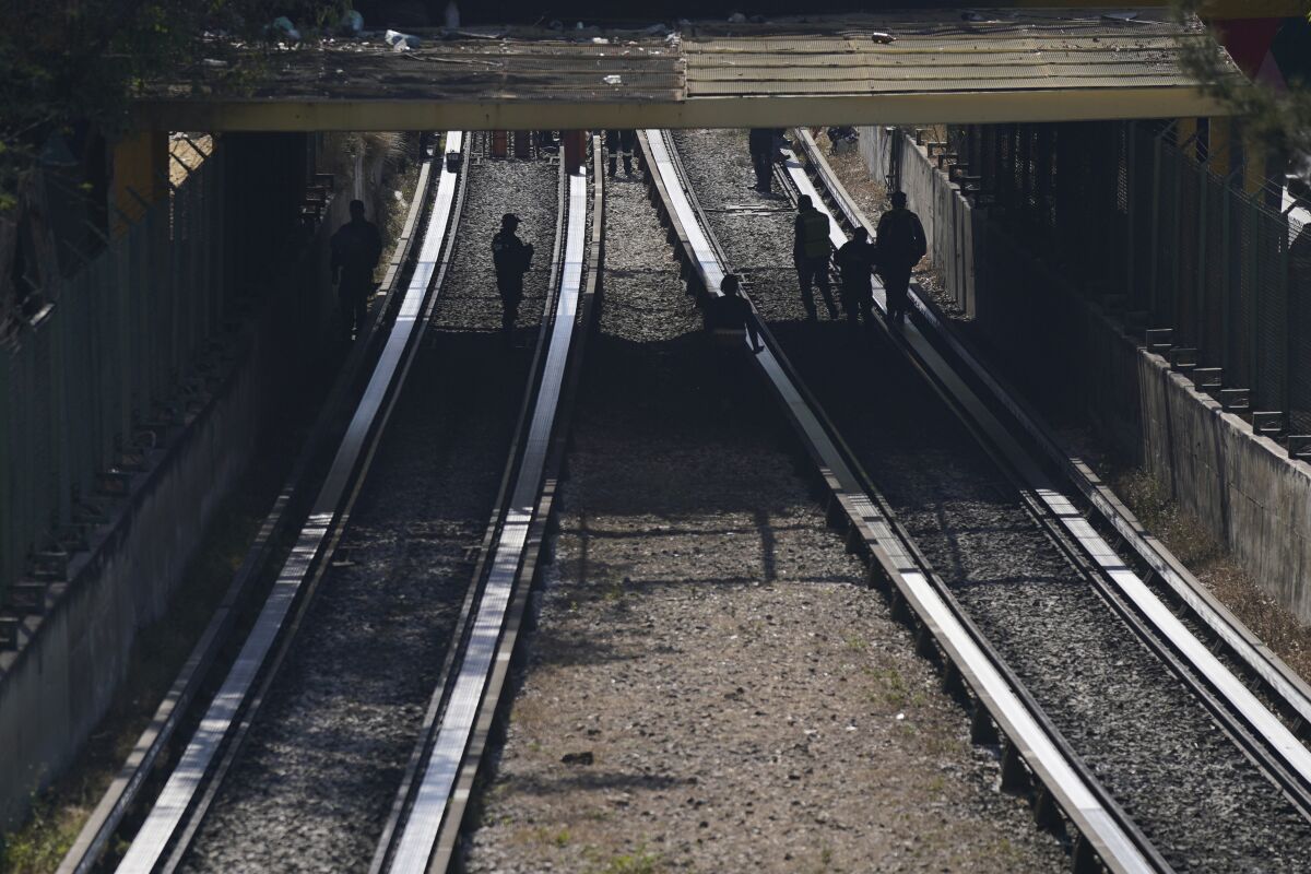 Los equipos de rescate inspeccionan las vías férreas después de que chocaran dos trenes subterráneos