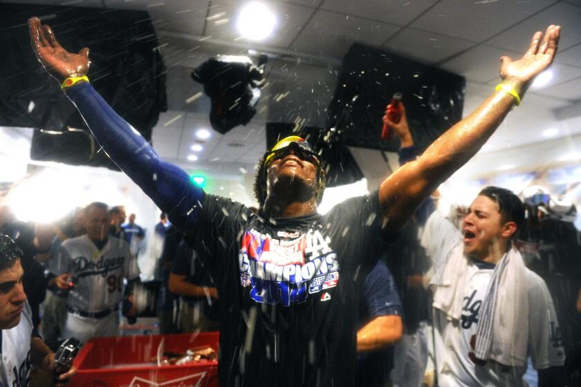 Dodgers center fielder Yasiel Puig celebrates with teammates in the clubhouse after defeating the Giants to win the NL West title.