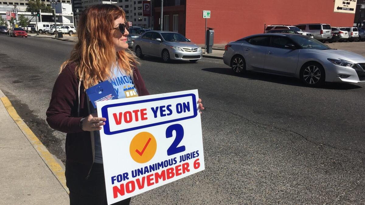 New Orleans resident Molly Ezell holds a sign promoting Amendment 2 in Louisiana.