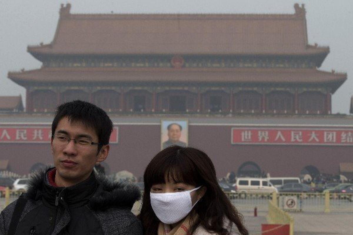 With air quality from Beijing to Guiyang at unprecedented lows, a visitor to Tiananmen Square wears a mask in the capital. Many people have refused to go outside.