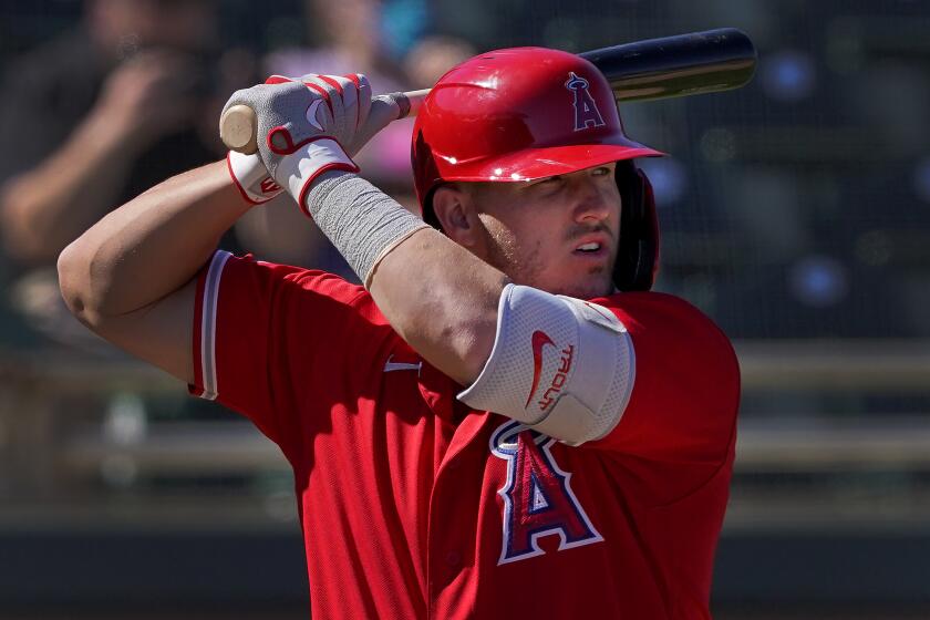Los Angeles Angels' Mike Trout hits against the Oakland Athletics during the third inning of a spring training.