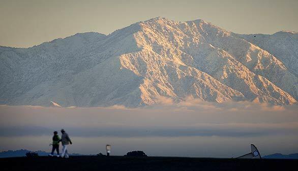 Snow-capped San Gabriel Mountains provide a winter backdrop at Bolsa Chica State Ecological Reserve in Huntington Beach. A storm Wednesday dropped the snow level to an unusually low 2,000 feet.