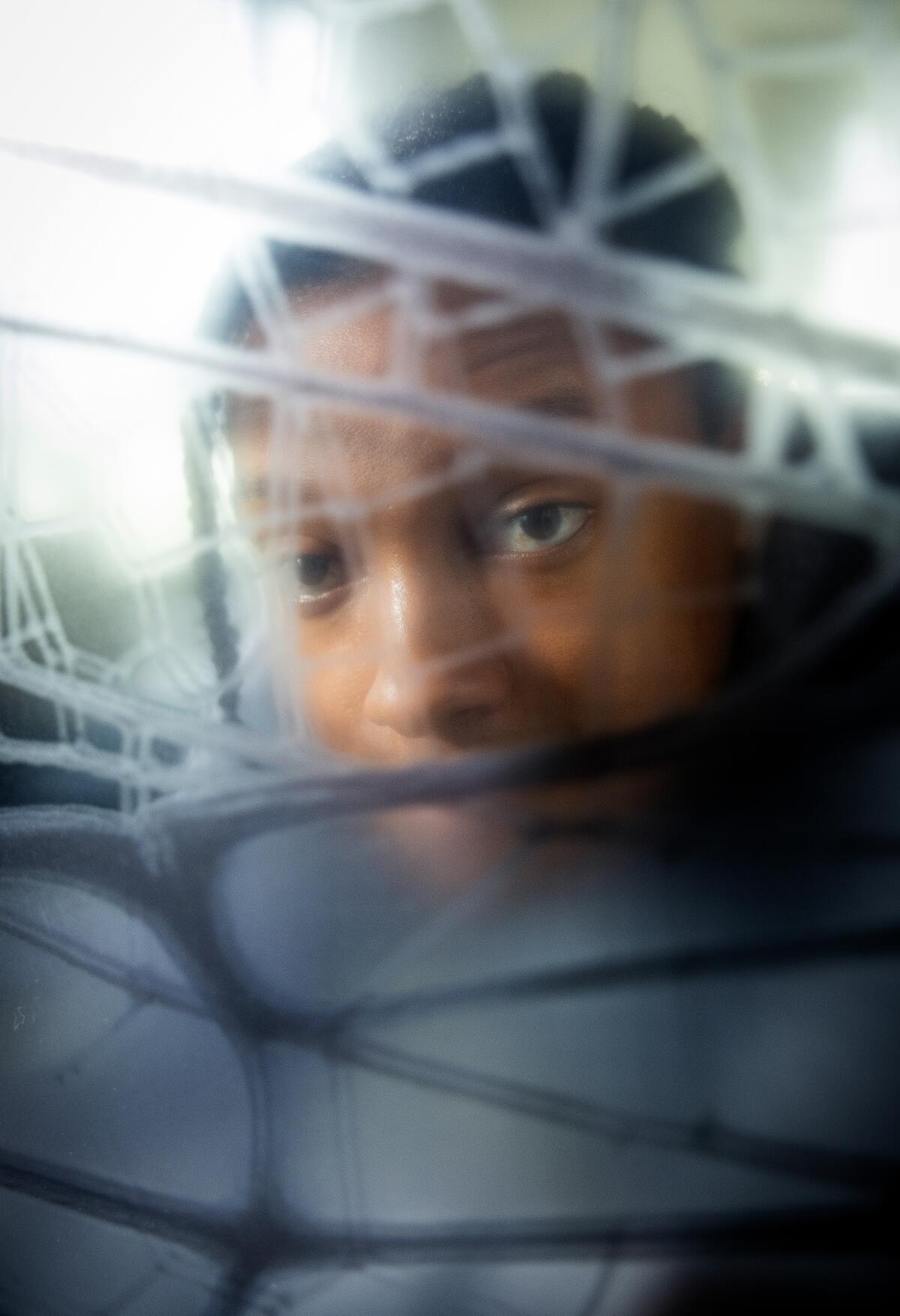 Comedian Josh Johnson photographed through mesh webbing