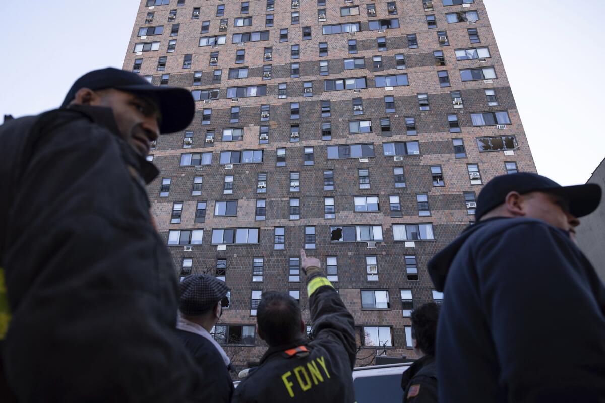 Firefighters look up at apartment building