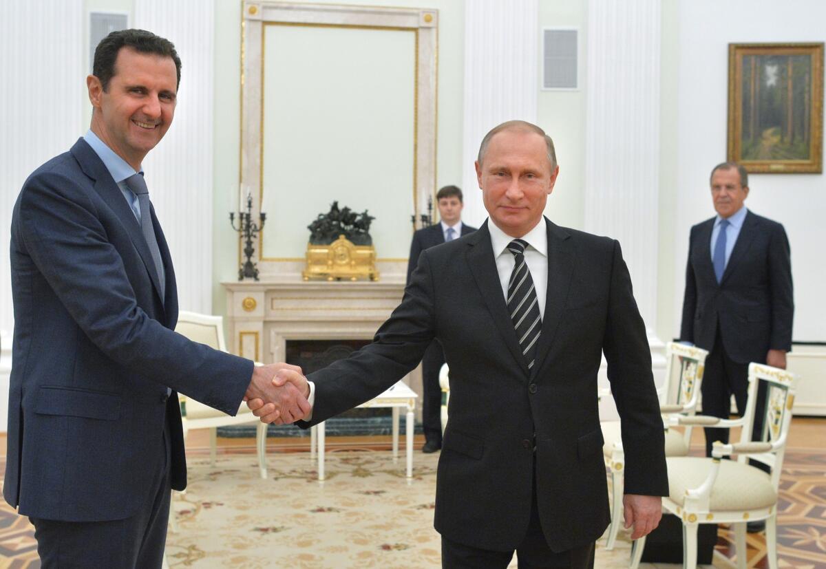 Russian President Vladimir Putin, center, shakes hands with Syrian President Bashar Assad as Russian Foreign Minister Sergey Lavrov, right, looks on in the Kremlin in Moscow, Russia in October of 2015.