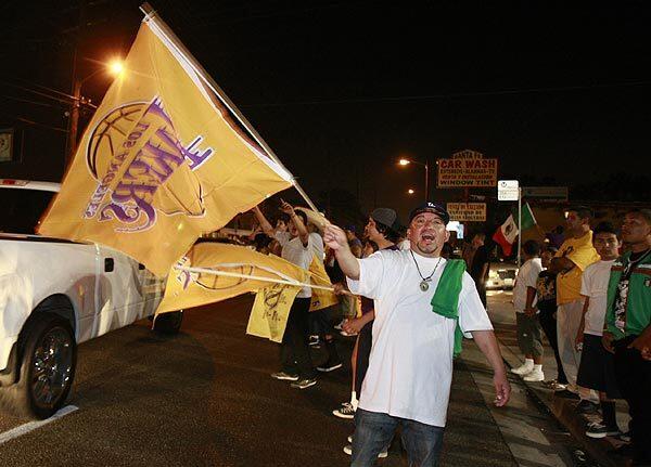 Lakers fans cheer at the intersection of Santa Fe and Florence avenues in Huntington Park.