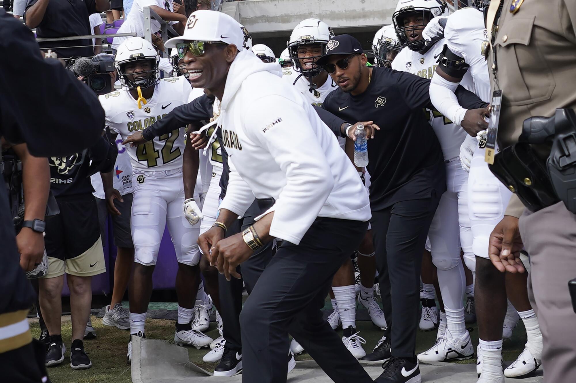 Colorado coach Deion Sanders fires up his team before running onto the field with his team 