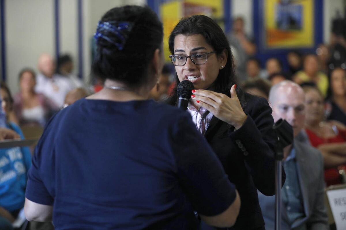 Congresswoman Nanette Diaz Barragán, right, tries to calm the concerns of Compton resident Maria Villarreal, who says brown water flows from the faucets of her home.