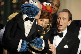 FILE - Bob McGrath, right, looks at the Cookie Monster as they accept the Lifetime Achievement Award for '"Sesame Street" at the Daytime Emmy Awards on Aug. 30, 2009, in Los Angeles. McGrath, an actor, musician and children’s author widely known for his portrayal of one of the first regular characters on the children’s show “Sesame Street” has died at the age of 90. McGrath’s passing was confirmed by his family who posted on his Facebook page on Sunday, Dec. 4, 2022. (AP Photo/Chris Pizzello, File)
