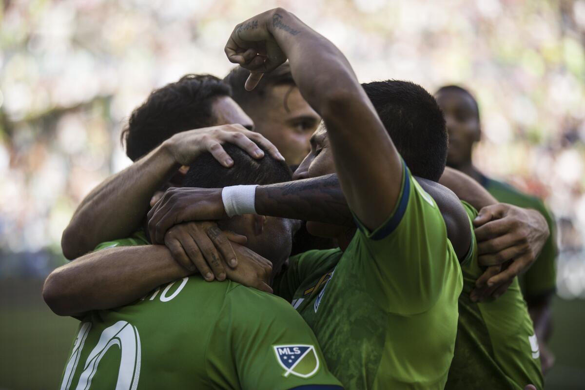 Raul Ruidiaz celebrates a goal, pointing at Nicolas Lodeiro who assisted late in the first half of the soccer match against the Los Angeles Galaxy at CenturyLink Field, Sunday, Sept. 1, 2019, in Seattle. (Rebekah Welch/The Seattle Times via AP)