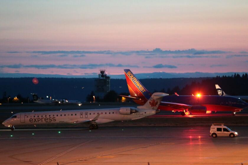 Planes sit on the tarmac at Sea-Tac International Airport after service was halted after an Alaska Airlines plane was stolen Friday, Aug. 10, 2018, in Wash. An airline mechanic stole an Alaska Airlines plane without any passengers and took off from Sea-Tac International Airport in Washington state on Friday night before crashing near Ketron Island, officials said. (Bettina Hansen /The Seattle Times via AP)