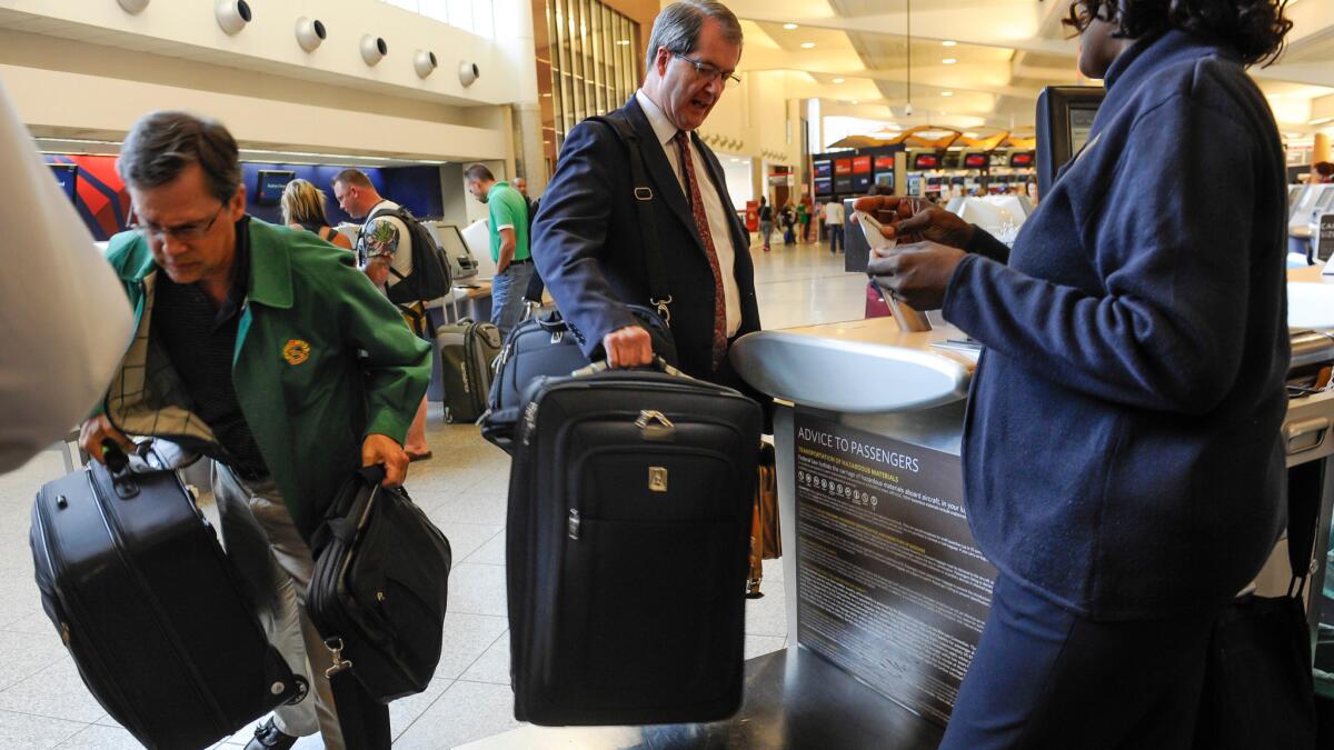 Passengers check their luggage at the Delta counter at Hartsfield-Jackson Atlanta International Airport. Bag fees and other passenger charges generated $40.5 billion for the world's biggest carriers last year.