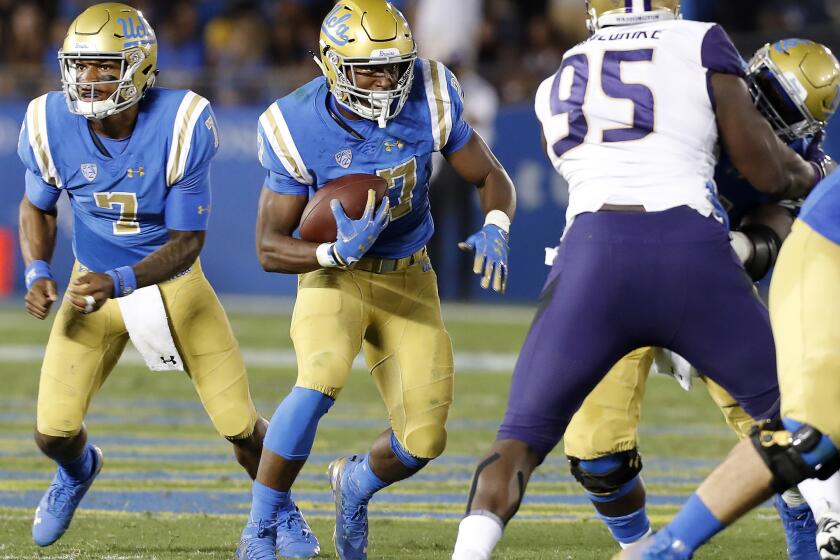 UCLA running back Joshua Kelly (27) looks for room to run against Washington in the third quarter on Saturday at the Rose Bowl.