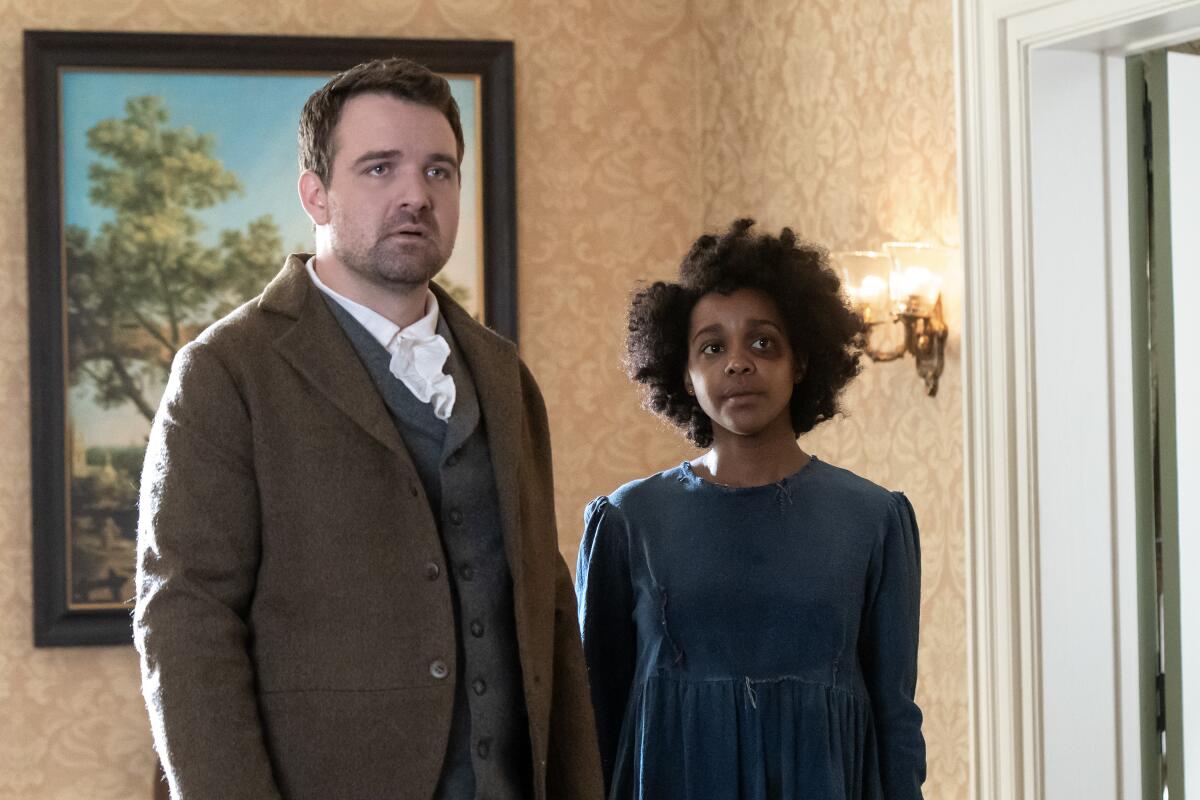 A white man, left, and a Black woman with a black eye in period clothing