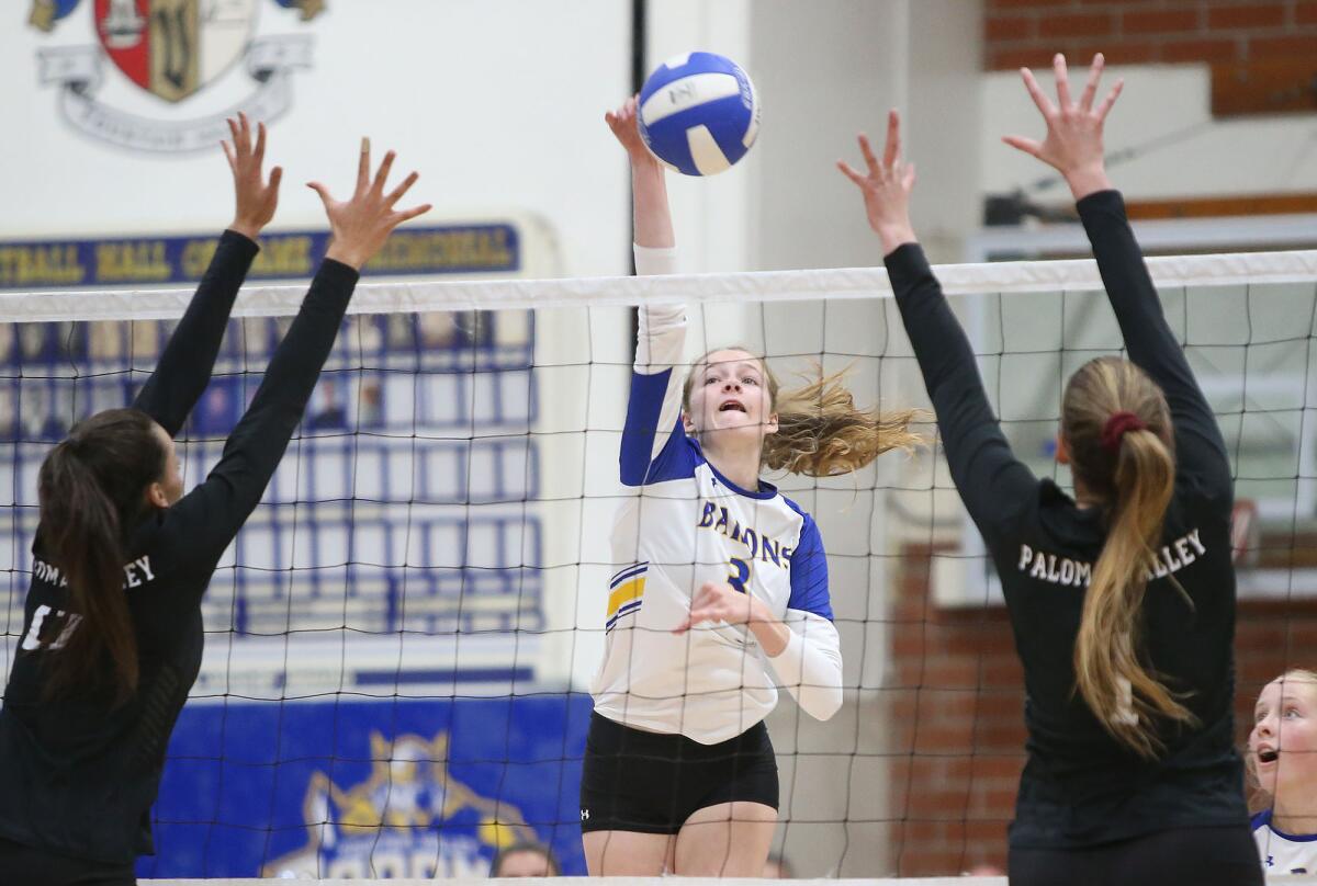 Fountain Valley's Juliette Bokor, center, hits a ball past Paloma Valley blockers Gabrielle Hollins, left, and Shannon Dunkin in the quarterfinals of the CIF Southern Section Division 3 playoffs at home on Wednesday.