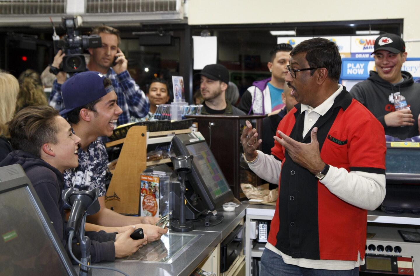 M. Faroqui, right, who sold the Powerball winning ticket at a 7-Eleven in Chino Hills, Calif. celebrates with a crowd in the store.