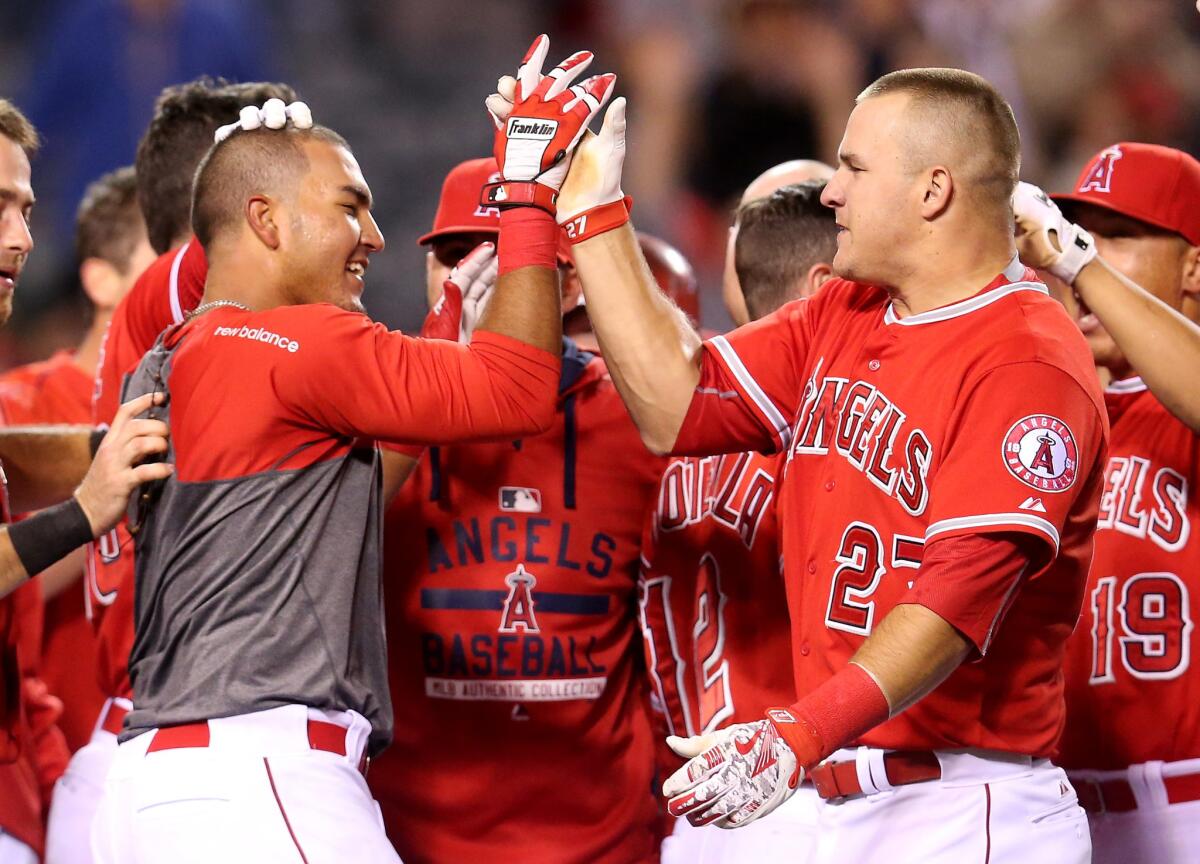 Carlos Perez celebrates with teammate Mike Trout after hitting a game-winning home run to give the Angels a 5-4 victory over Seattle in his major league debut.