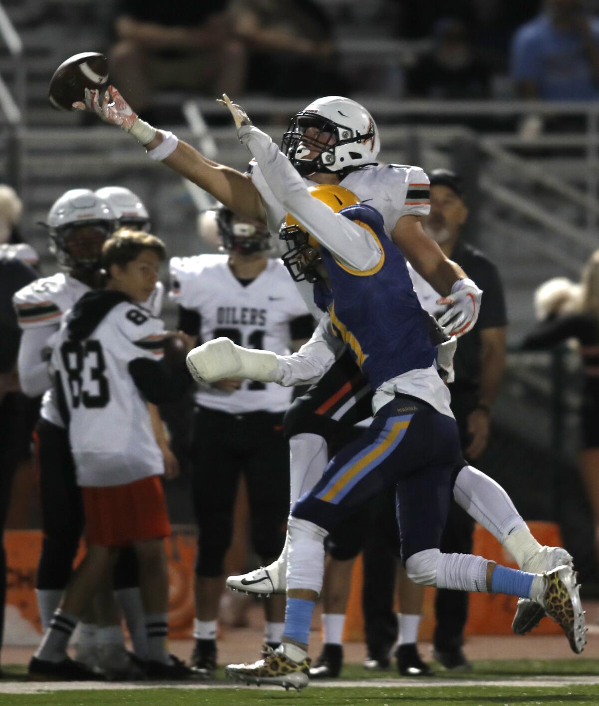 Marina's Ronny Slavens (7) defends a pass to Huntington Beach's Christian Moore in the Oil vs. Water rivalry game at Westminster High on Sept. 20, 2019.