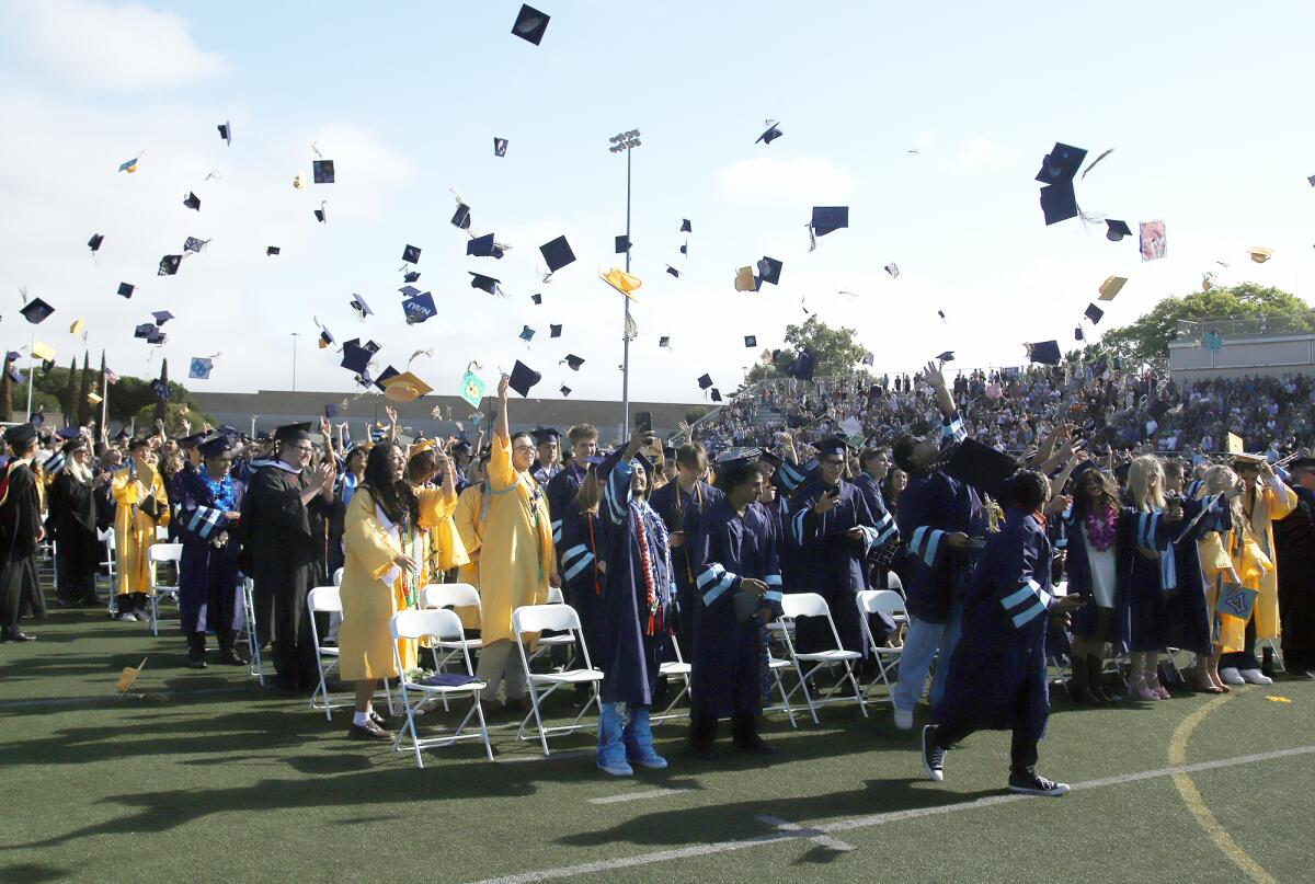 Marina High School graduates throw their caps into the air after officially graduating on Thursday.