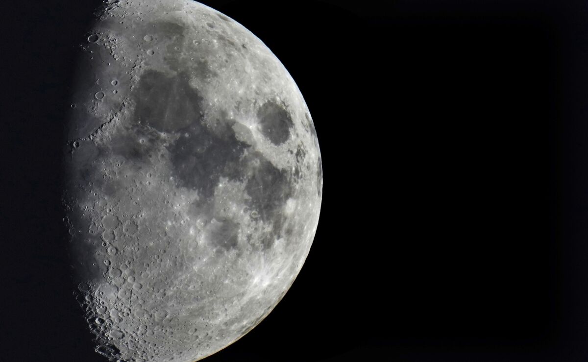 FILE - Impact craters cover the surface of the moon, seen from Berlin, Germany, Tuesday, Jan. 11, 2022. The moon is about to get walloped by 3 tons of space junk, a punch that will carve out a crater that could fit several semitractor-trailers. A leftover rocket is expected to smash into the far side of the moon at 5,800 mph (9,300 kph) on Friday, March 4, 2022, away from telescopes’ prying eyes. It may take weeks, even months, to confirm the impact through satellite images. (AP Photo/Michael Sohn, File)