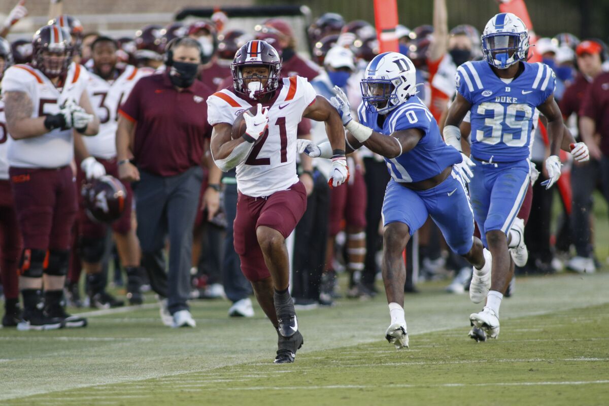 Virginia Tech running back Khalil Herbert (21) breaks free for a first-down run ahead of Duke safety Marquis Waters (0) and cornerback Jeremiah Lewis (39) during the second half of an NCAA college football game Saturday, Oct. 3, 2020, in Durham, N.C. (Nell Redmond/Pool Photo via AP)