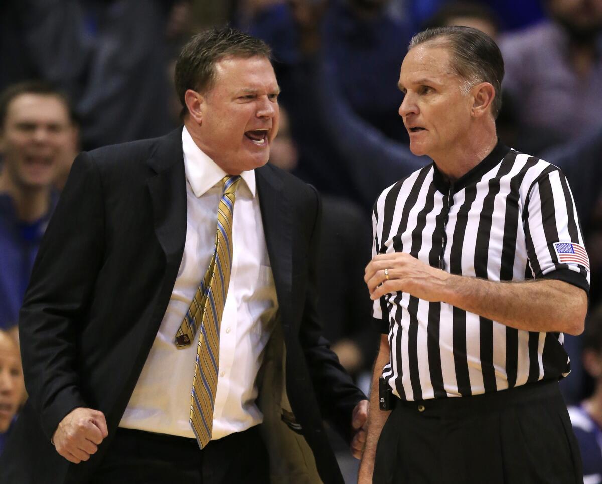 Kansas Coach Bill Self, left, objects to a call by referee Kelly Self, right, during the first half and receivers a technical foul.