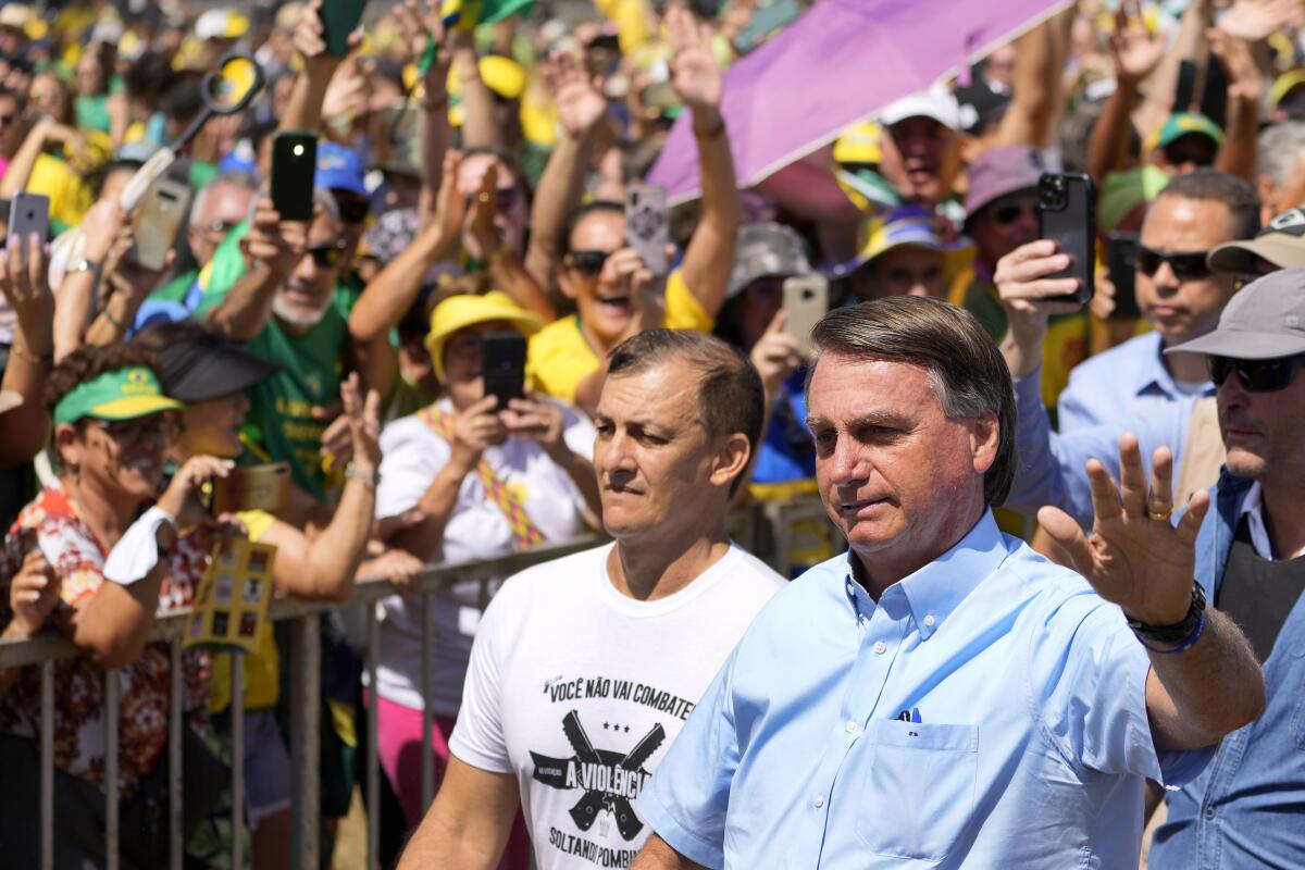 Brazil's President Jair Bolsonaro waves to supporters in Brasilia, Brazil.