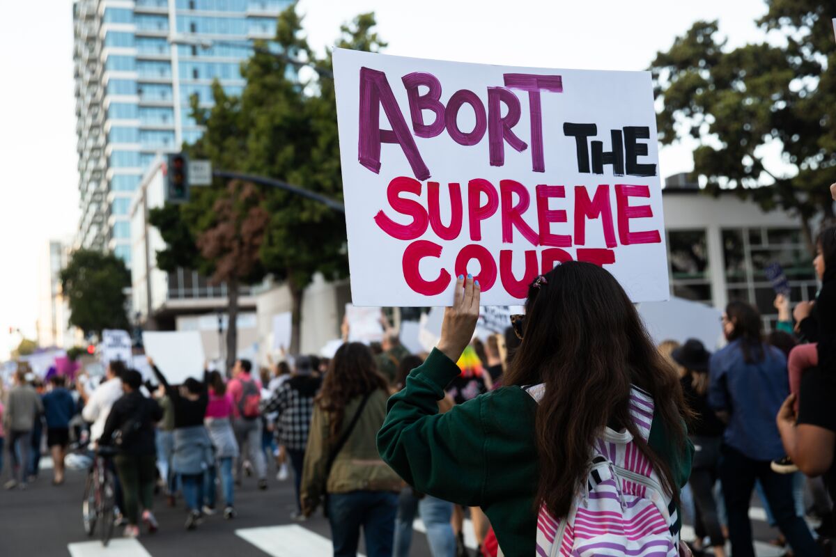 Demonstrators march Wednesday through downtown protest against Supreme Court draft decision that could overturn Roe v. Wade