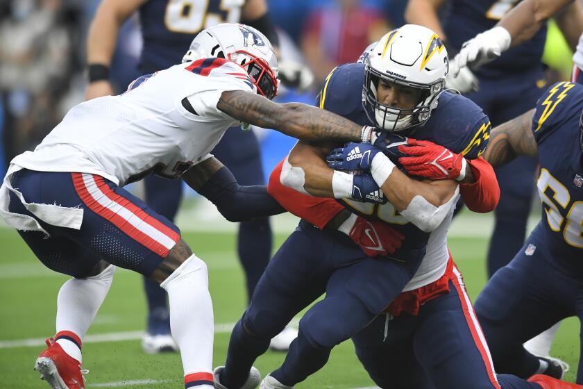 Chargers running back Austin Ekeler is tackled against the New England Patriots on Oct. 31, 2021.