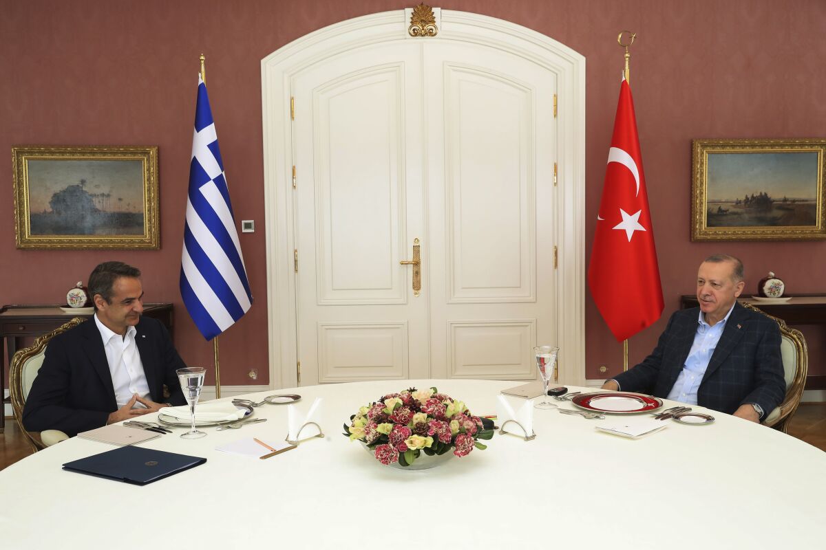 In this photo provided by Turkish Presidency, Greek Prime Minister Kyriakos Mitsotakis, left, talks to Turkish President Recep Tayyip Erdogan during their meeting in Istanbul, Turkey, Sunday, March 13, 2022. Mitsotakis is in Istanbul to talk with Turkish President Recep Tayyip Erdogan in a rare meeting between the neighbors who have been at odds over maritime and energy issues, the status of Aegean islands and migration. (Turkish Presidency via AP)