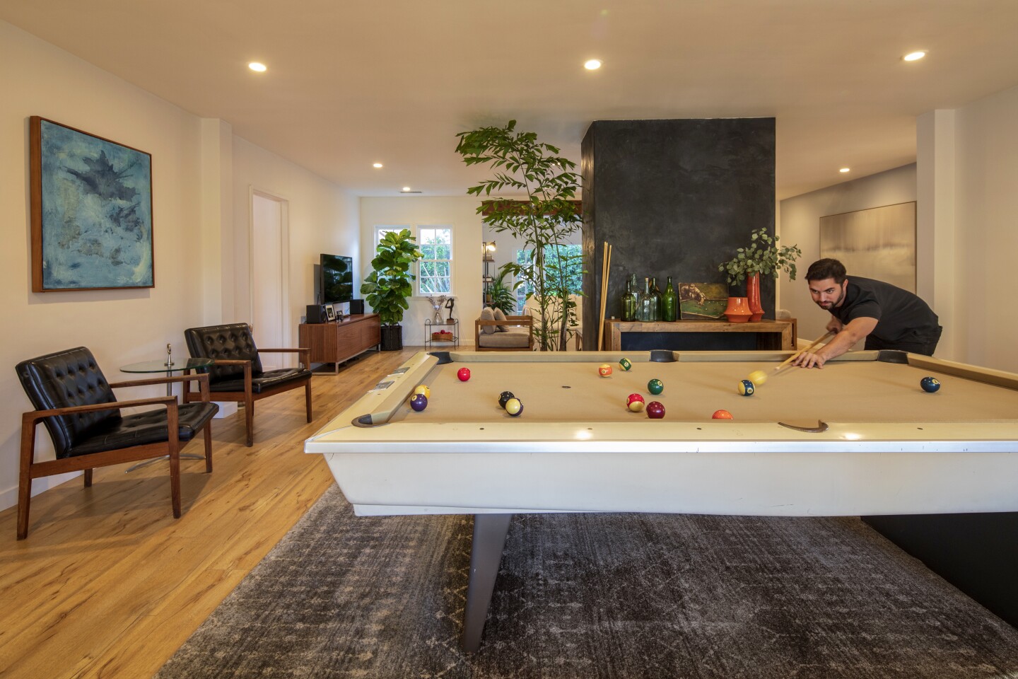 In Sam Leiaghat's family-friendly Studio City neighborhood, passers-by have no clue that behind the postwar façade of his 1941 Ranch lies a surprisingly sleek and sunny bachelor pad – complete with a Brunswick pool table in the living room.