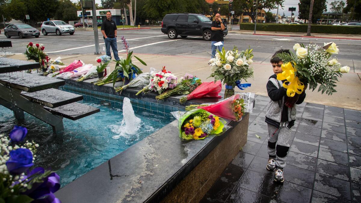 Lincoln Ayala, 5, carries a bouquet of roses to lay at an impromptu memorial for fallen Pomona Police Officer Gregory Casillas on Saturday.