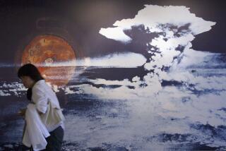 HIROSHIMA, JAPAN - AUGUST 5: A visitor passes by a wall displaying a picture of the mushroom cloud pictured when the atomic bomb was dropped on August 5, 2004 in Hiroshima, Japan. Tomorrow Hiroshima will mark the 59th anniversary of the dropping of the first atomic bomb in Hiroshima at the Hiroshima Peace Memorial Park. (Photo by Junko Kimura/Getty Images)