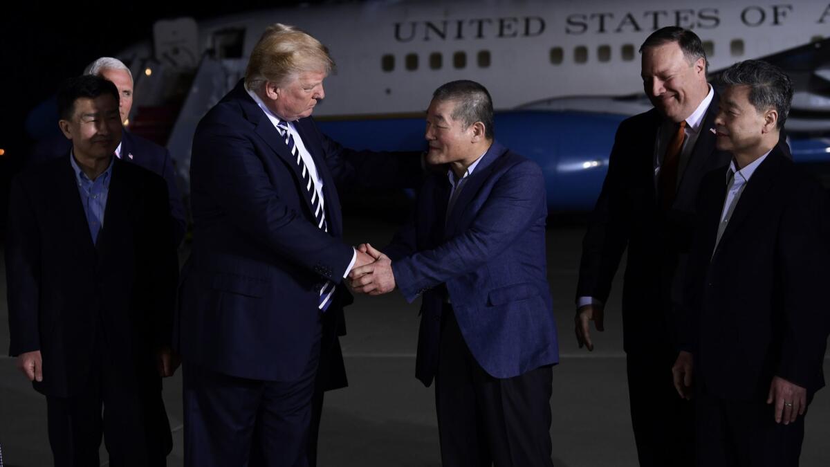 President Trump shakes hands with Kim Dong Chul, Tony Kim, far left and Kim Hak Song, far right, the three Americans who were detained in North Korea.
