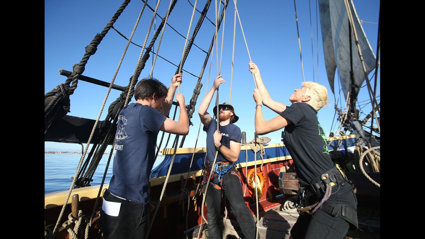 Crew members Brock Contreras, Rory Kane and Caryn Anderson pull lines as they secure one of 14 sails aboard the tall ship Lady Washington as it enters Newport Harbor from Dana Point on Wednesday.