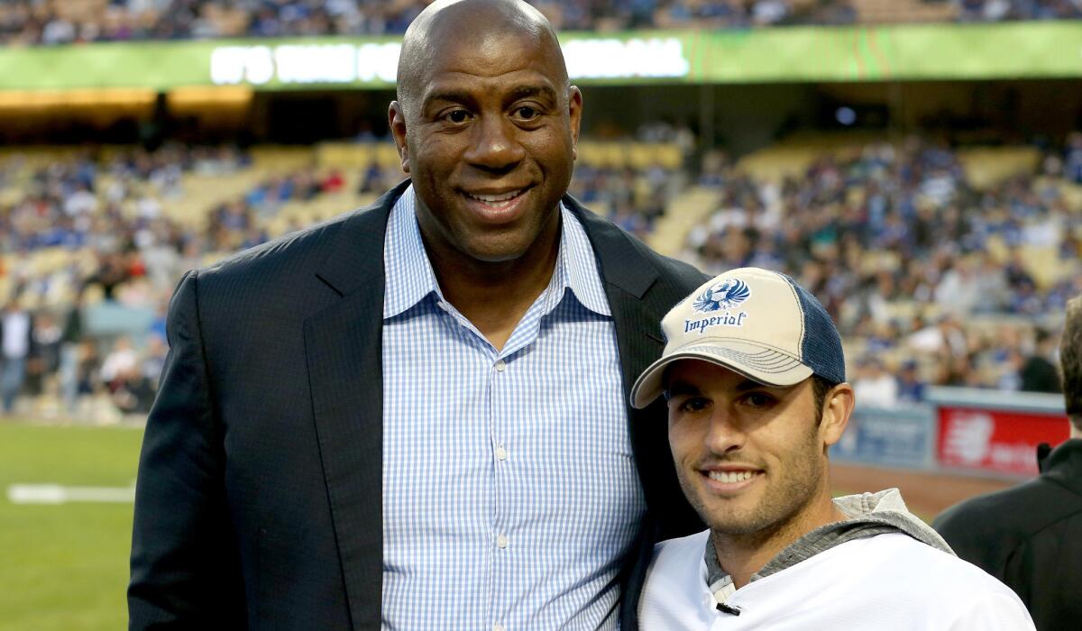 Dodgers owner and former Lakers great Magic Johnson poses for a photo with former U.S. soccer star Landon Donovan before a game at Dodger Stadium on April 8.