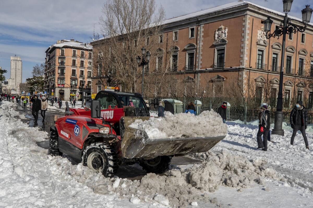 Una barredora despeja nieve en el centro de Madrid, España, el domingo 10 de enero de 2021. (AP Foto/Manu Fernández)