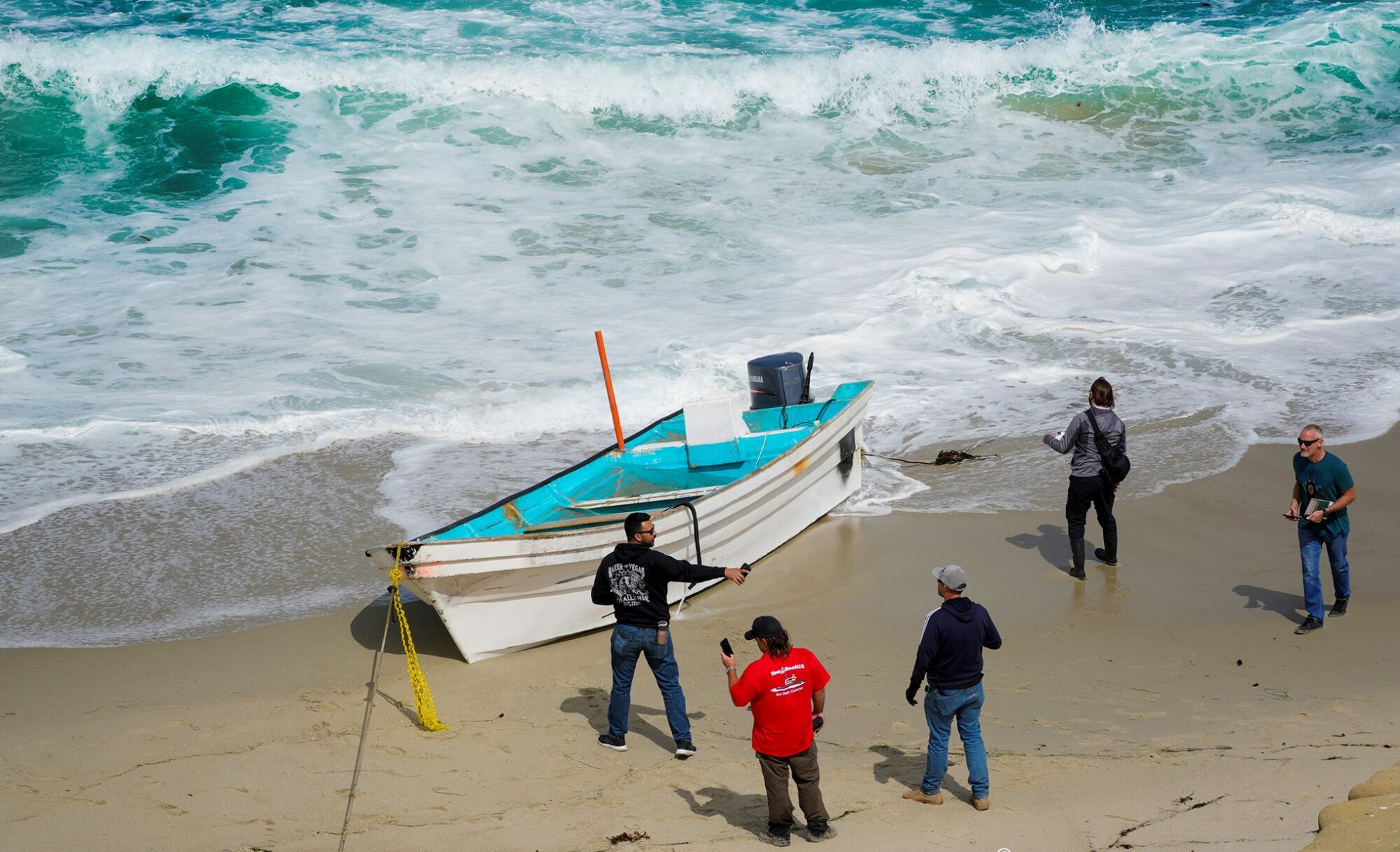 A panga rests on the shore in La Jolla in May 2021 after it capsized in the surf. One person died and 10 others were rescued.