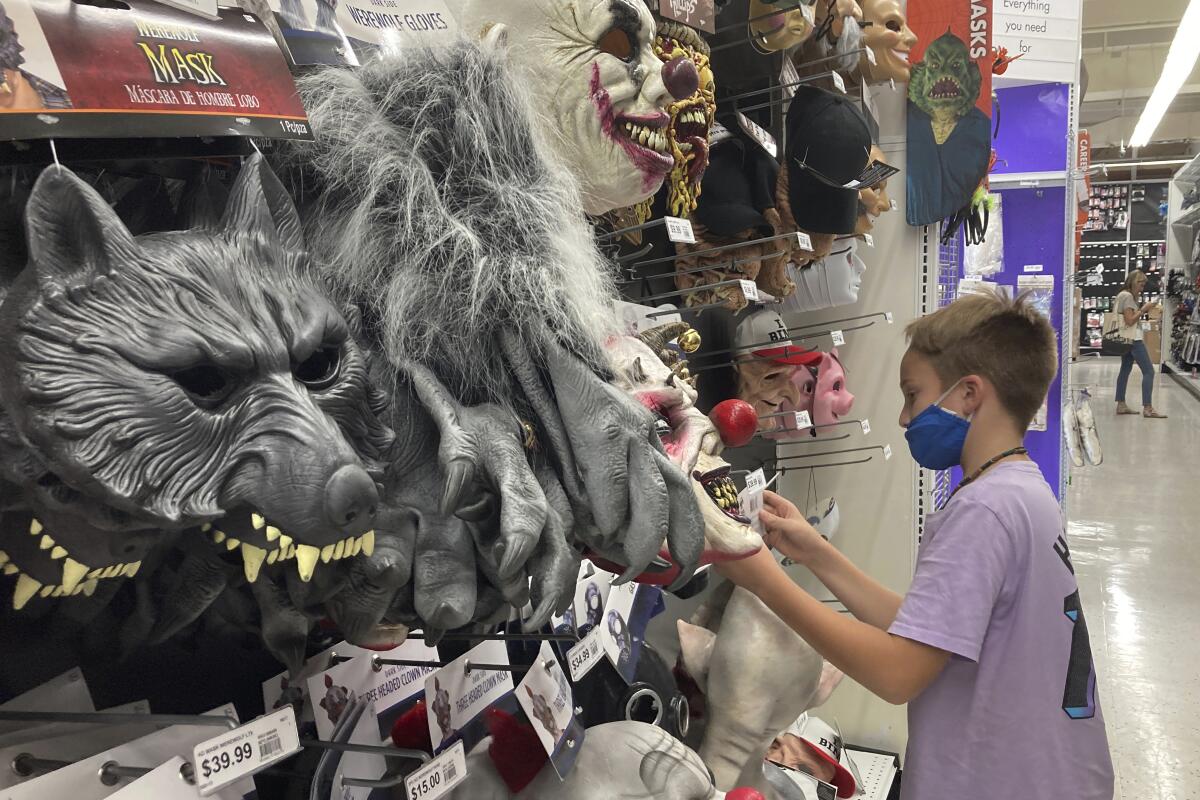 Un niño mira máscaras de Halloween en una tienda Party City 