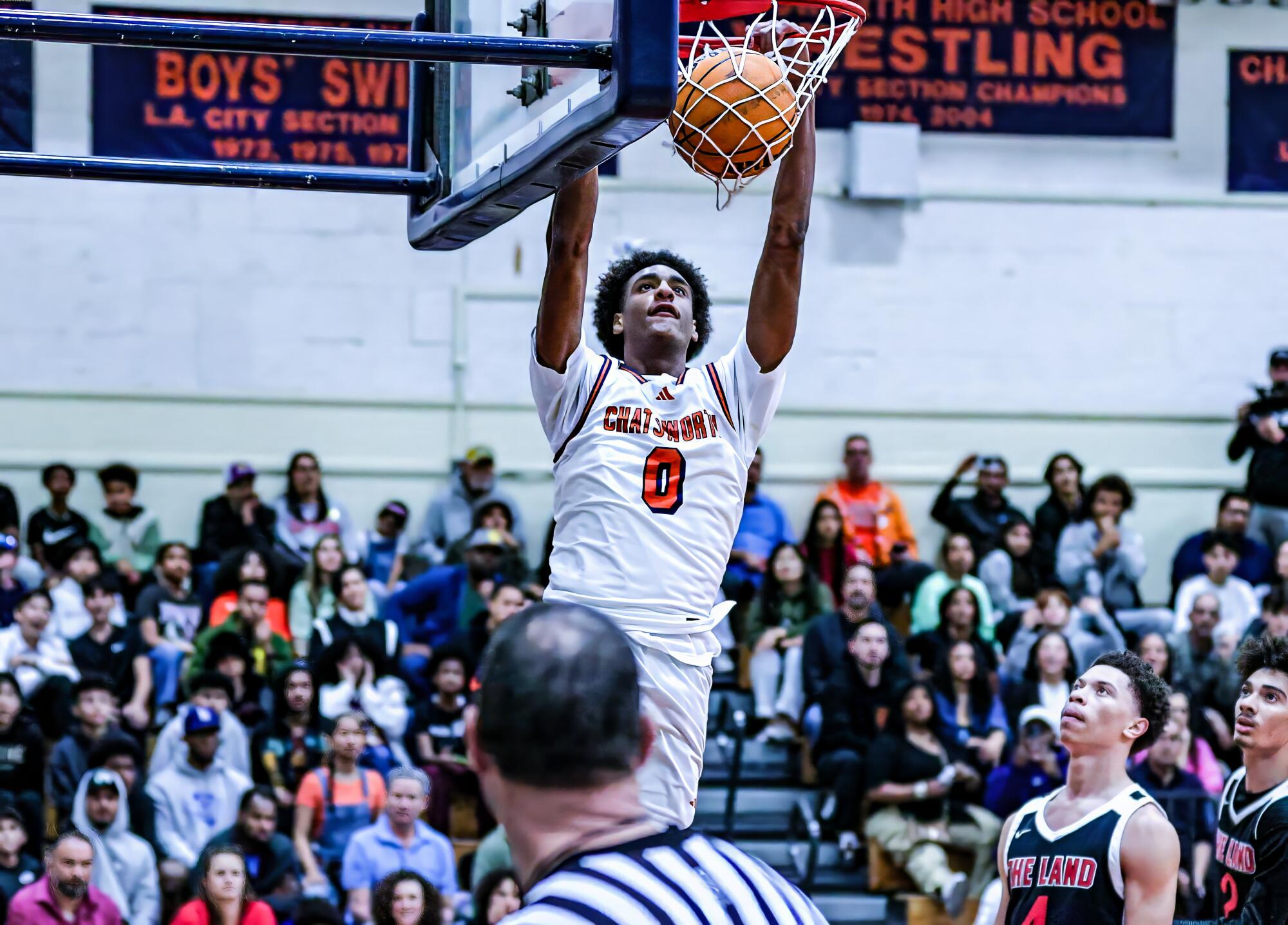 Alijah Arenas dunks the ball during a high school basketball game.