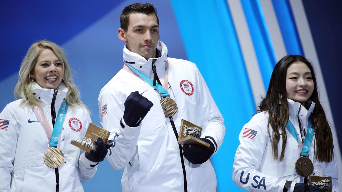 U.S. figure skaters Alexa Scimeca Knierim, left, Chris Knierim and Maia Shibutani celebrate after receiving their bronze medals for the team event.