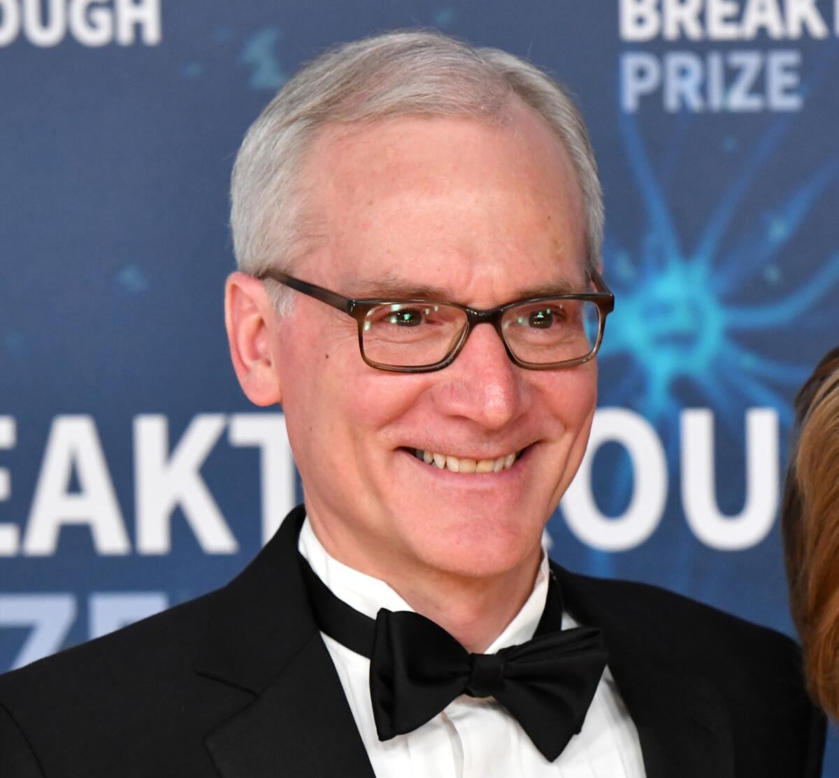 A smiling man wearing eyeglasses and a bow tie.