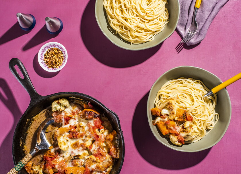 Pizza mozz in a cast iron skillet with a side of garlicky spaghetti