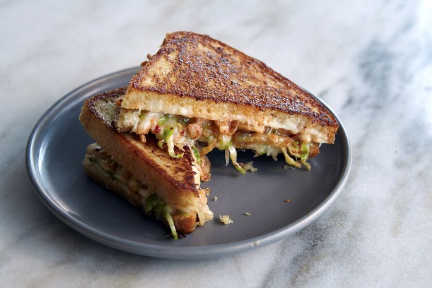 A grilled cheese with golden-brown bread, kimchi and cheese.