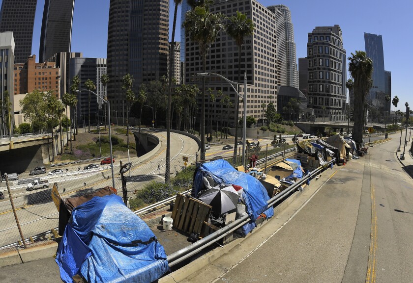 FILE - This May 21, 2020, file photo, shows a homeless encampment on Beaudry Avenue as traffic moves along Interstate 110 below during the coronavirus outbreak, in downtown Los Angeles. Los Angeles County will resume its annual homeless count in full a year after it was limited over concerns that it couldn't be done safely or accurately during the coronavirus pandemic, officials said Thursday, Jan. 6, 2022. (AP Photo/Mark J. Terrill, File)