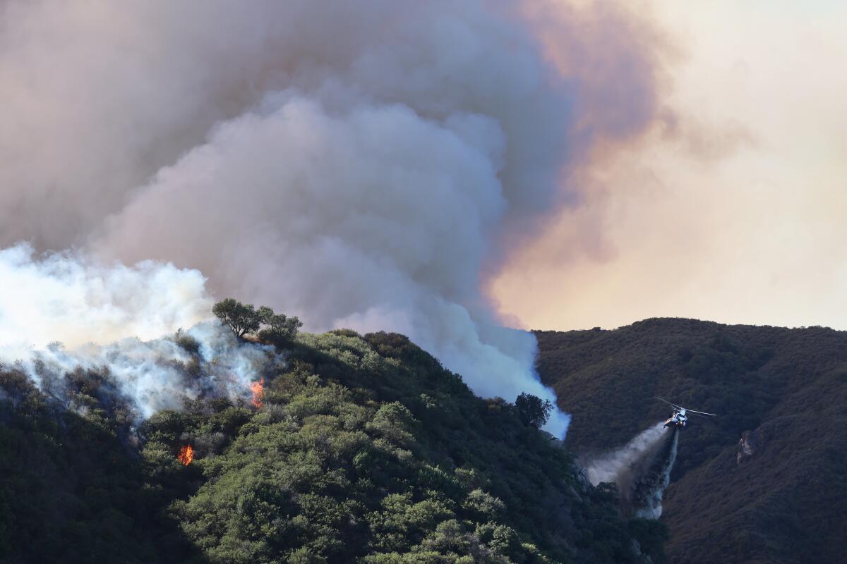 Smoke billows over hilly terrain