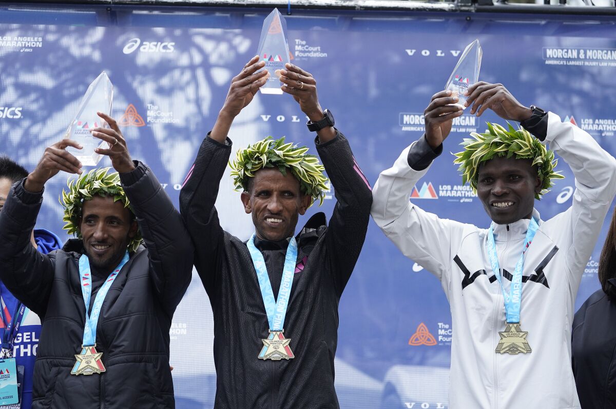Marathon runners from left: Yemane Tsegay of Ethiopia, Jemal Yimer of Ethiopia, the winner of the Los Angeles Marathon men's elite, and Barnaba Kipkoech of Kenya pose for a picture in Los Angeles, Sunday, March 19, 2023. (AP Photo/Damian Dovarganes)