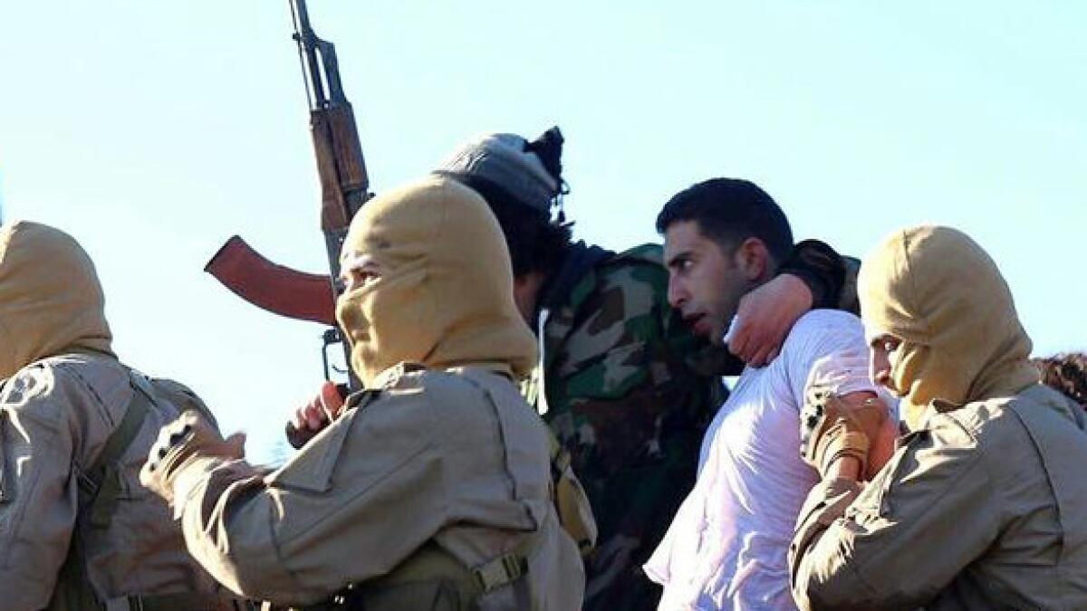 This image posted by the Raqqah Media Center, which monitors events in territory controlled by Islamic State militants with the permission of the extremist group, reportedly shows militants with the captured Jordanian pilot in Raqqah, Syria, on Dec. 24.
