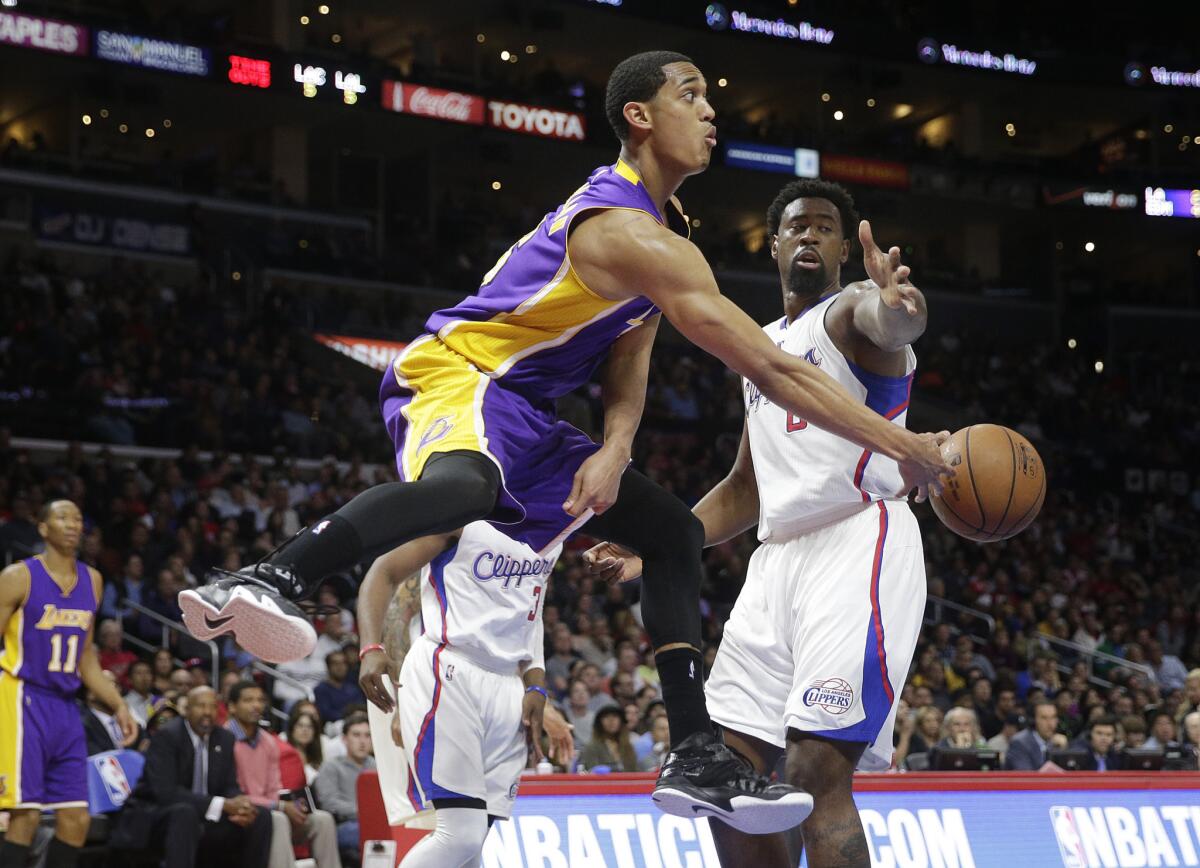 Lakers guard Jordan Clarkson passes the ball under pressure from Clippers center DeAndre Jordan during the second half of the Lakers' loss Tuesday night at Staples Center.